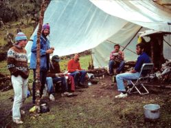 a group of researchers sitting around a campsite